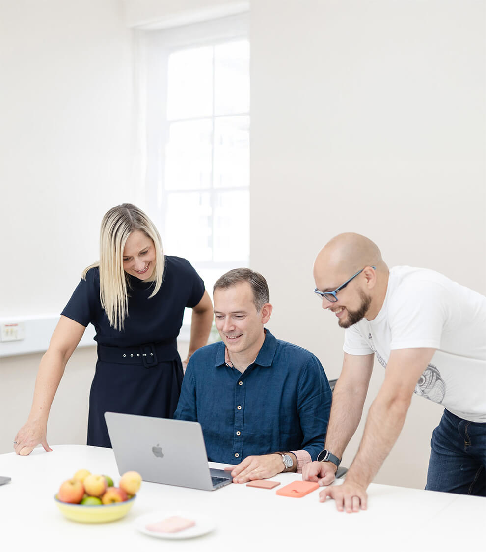 Three people using a laptop to look at Timemarker